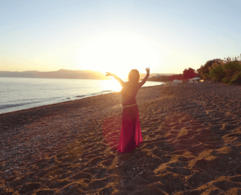 Iris tanzt am Strand vor dem Sonnenaufgang
