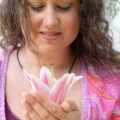 Iris mit pinker Lilienblüte in der Hand