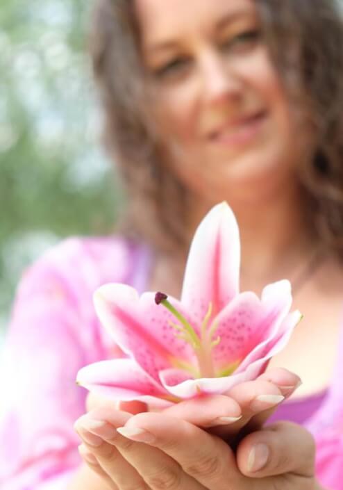 Iris mit pinker Lilienblüte in der Hand