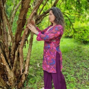Iris meditativ einen Baum berührend
