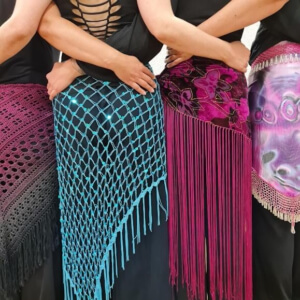Frauen mit dem Rücken zur Kamera, zeigen ihre Hüfttücher