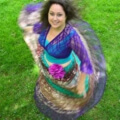 Iris tanzt in schönen bunten Kleidern auf der Wiese